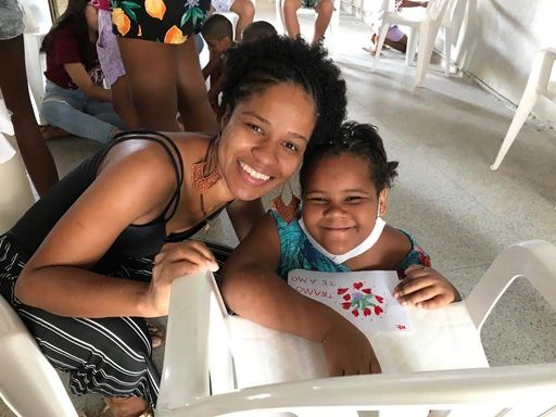 Voluntária e criança sorrindo durante atividade